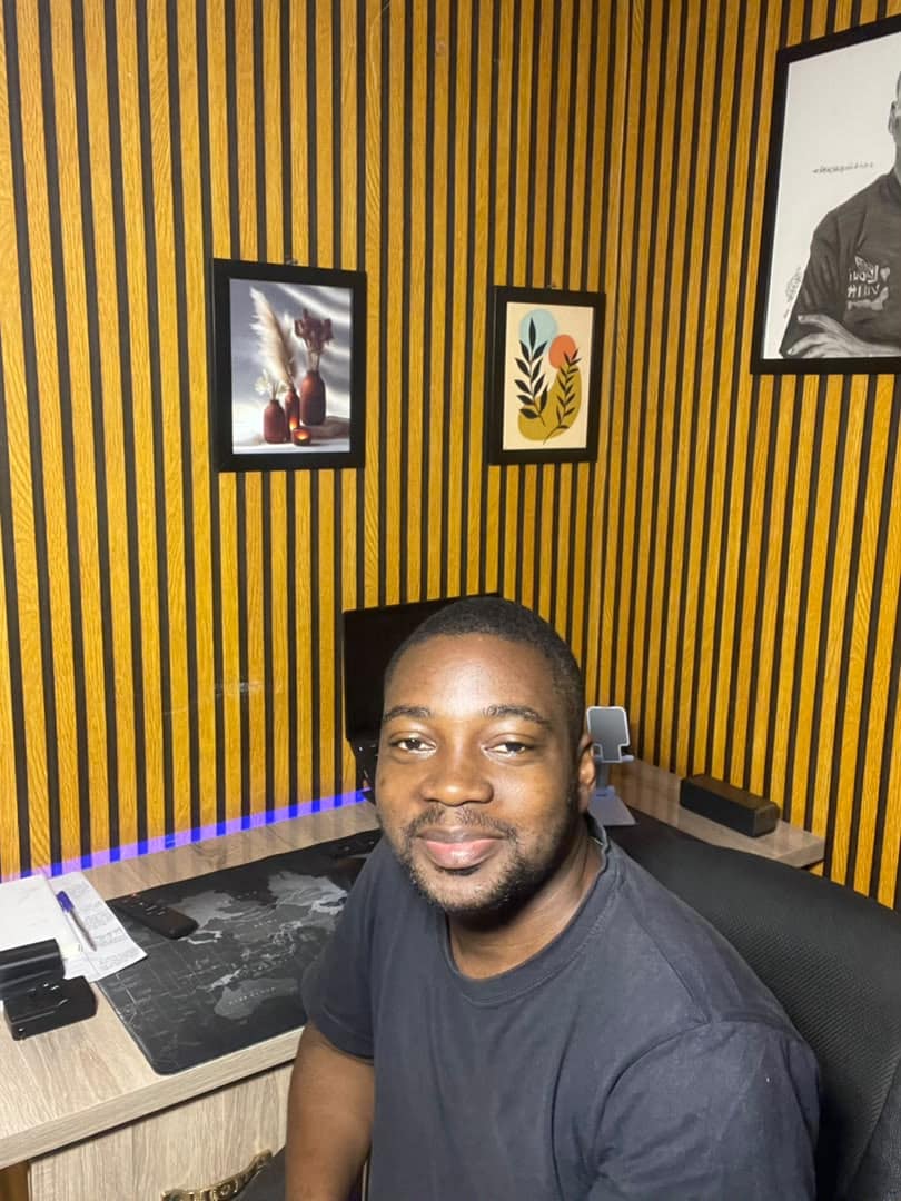 Joseph Kazeem smiling at the desk